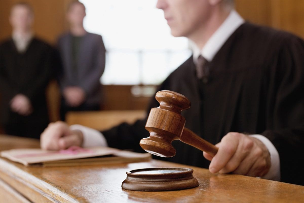 Judge holding gavel in courtroom